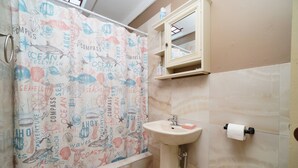 Ein Badezimmer mit Duschvorhang, der Meeresmotive und Seetiere zeigt, einem Waschbecken und einem Spiegelkorpus.