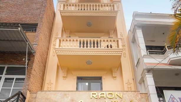 The exterior of RAON Central Hotel with a marble facade, a balcony, and a large glass entrance. - RAON Central Hotel (Xuan Huong - Da Lat)