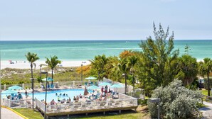 A pool area with a view of the beach and ocean.