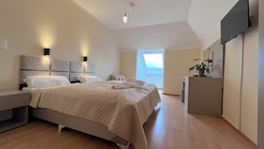 A bedroom with a bed, bedside tables, a desk, a TV, and a window. - La Melis  (Geldern)