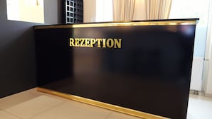 A reception desk with a black surface and gold trim. - La Melis  (Geldern)