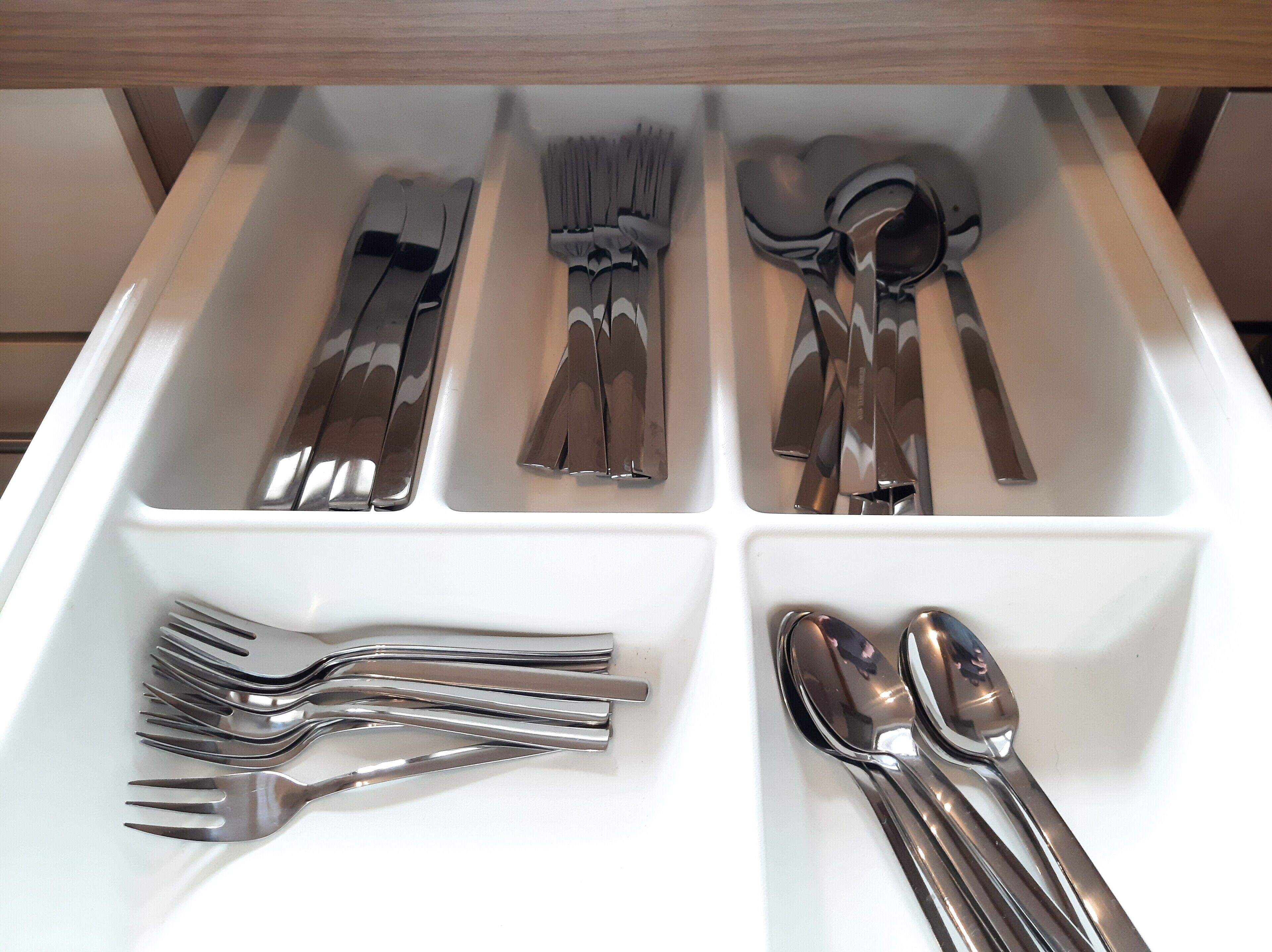 A drawer with neatly organized cutlery including forks, knives, and spoons.