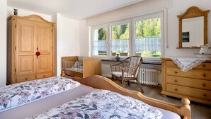 Makuuhuoneessa on kaksi sänkyä, puinen vaatekaappi, tuoli, lipasto ja ikkuna, josta avautuu näkymä vehreään maisemaan.