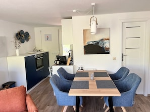 A compact living space with a kitchenette, dining area, and a door.