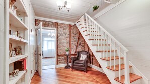 A staircase with white railings and wooden steps leading to a second floor. - Historical 1835 Home in Grand Coteau! (Grand Coteau)