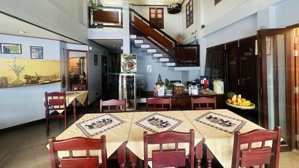 Un comedor con techo alto, una escalera y vistas a la cocina.