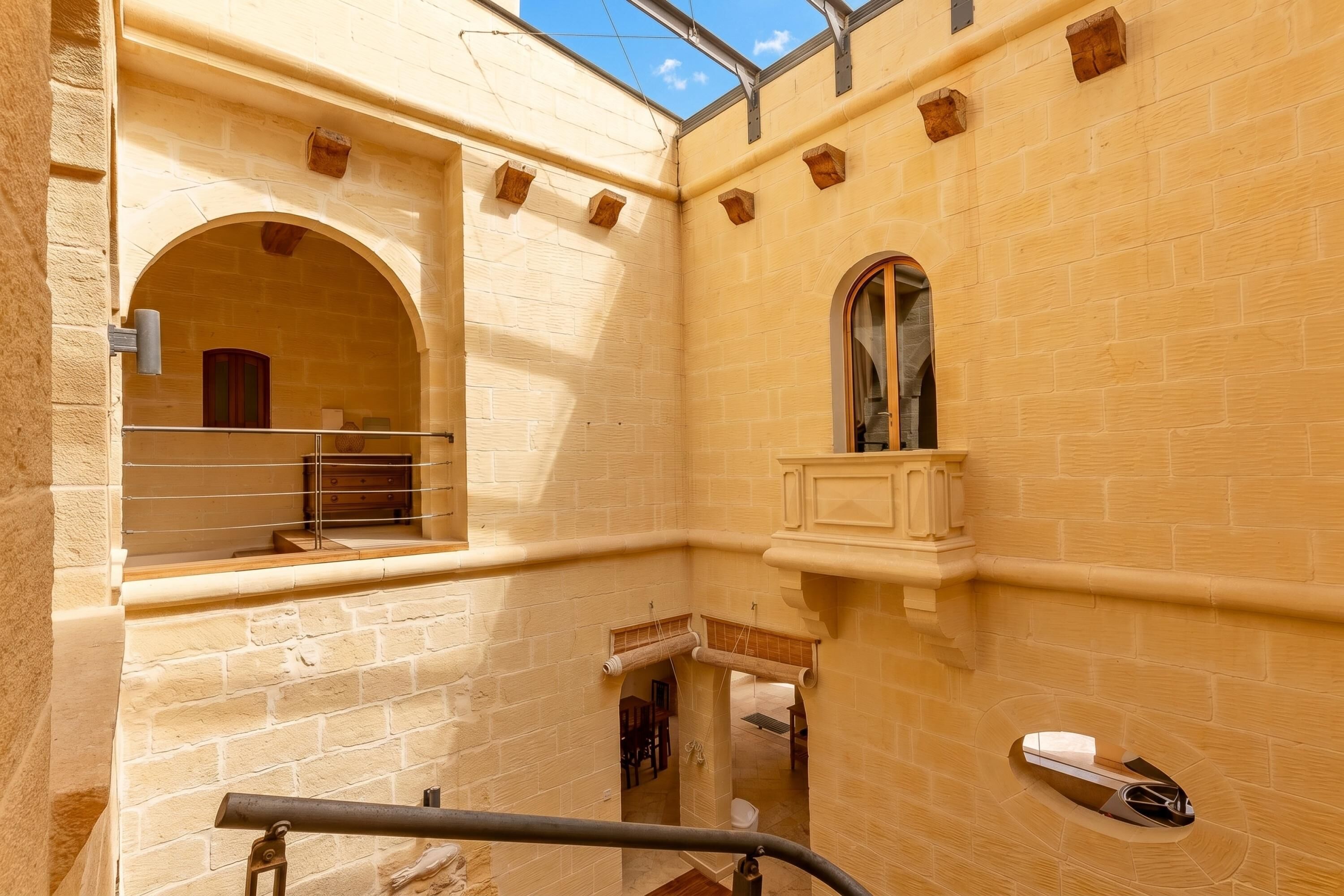 A narrow corridor with a small window, a wooden bench, and a handrail.