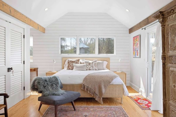 Une chambre à coucher avec un lit, une chaise, une fenêtre et une porte.