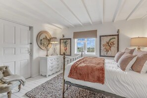 A bedroom with a bed, a dresser, a chair, and a window with a view. - Hiron's Piece and Honeysuckle Cottage with Hot Tub (Weston Subedge)