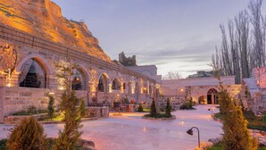 A historic stone building with arched windows and a courtyard. - Sur Cave Hotel (Ürgüp)