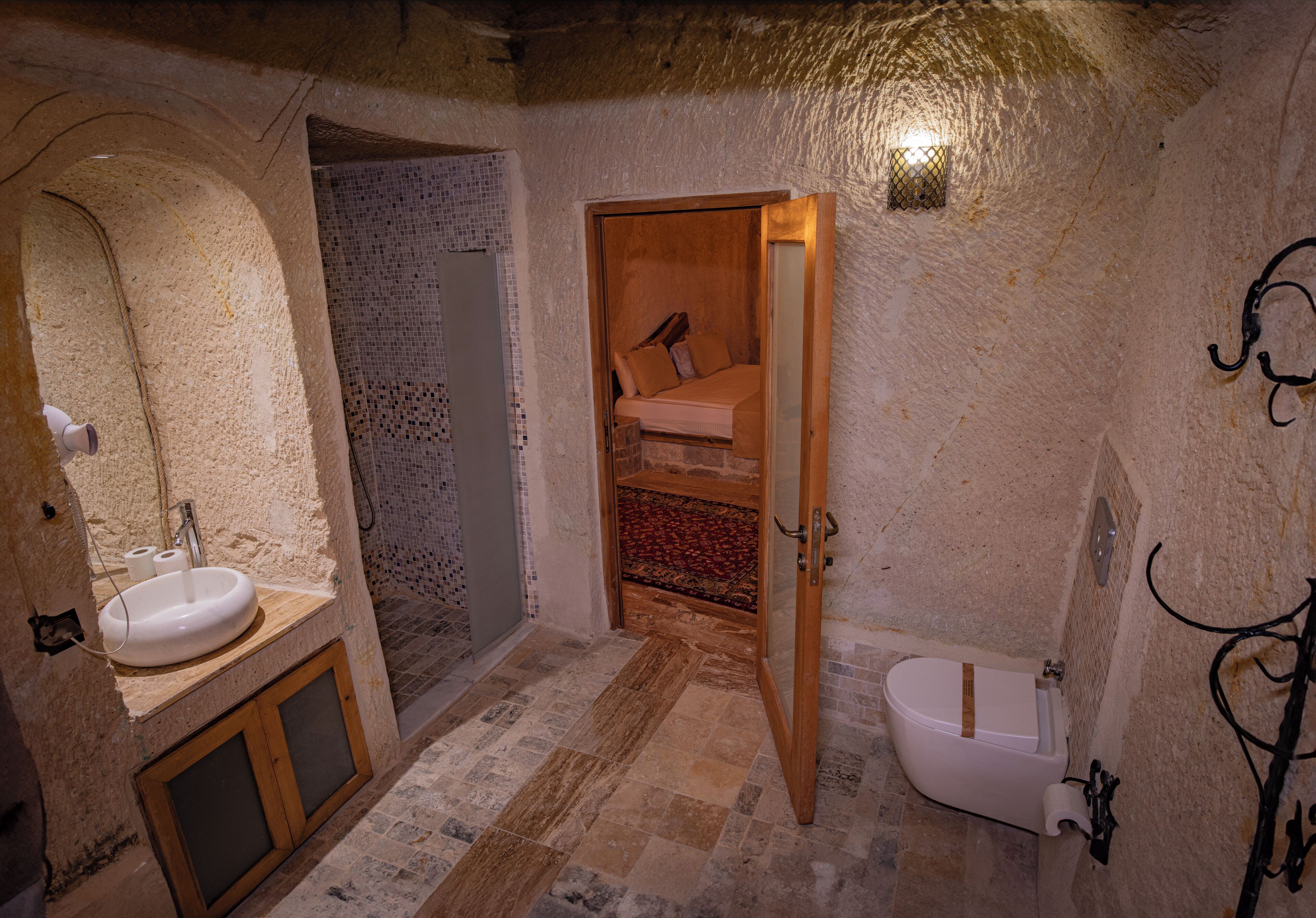 A rustic bathroom with a wooden door, a sink, and a toilet.
