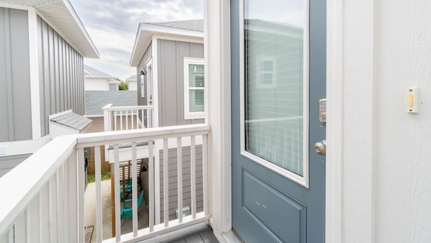 Un edificio residenziale con una porta blu, ringhiere bianche e un balcone.