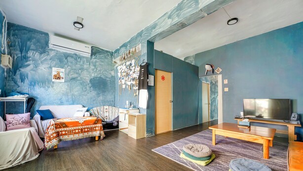 Una habitación con cama, escritorio, televisor y sofá.