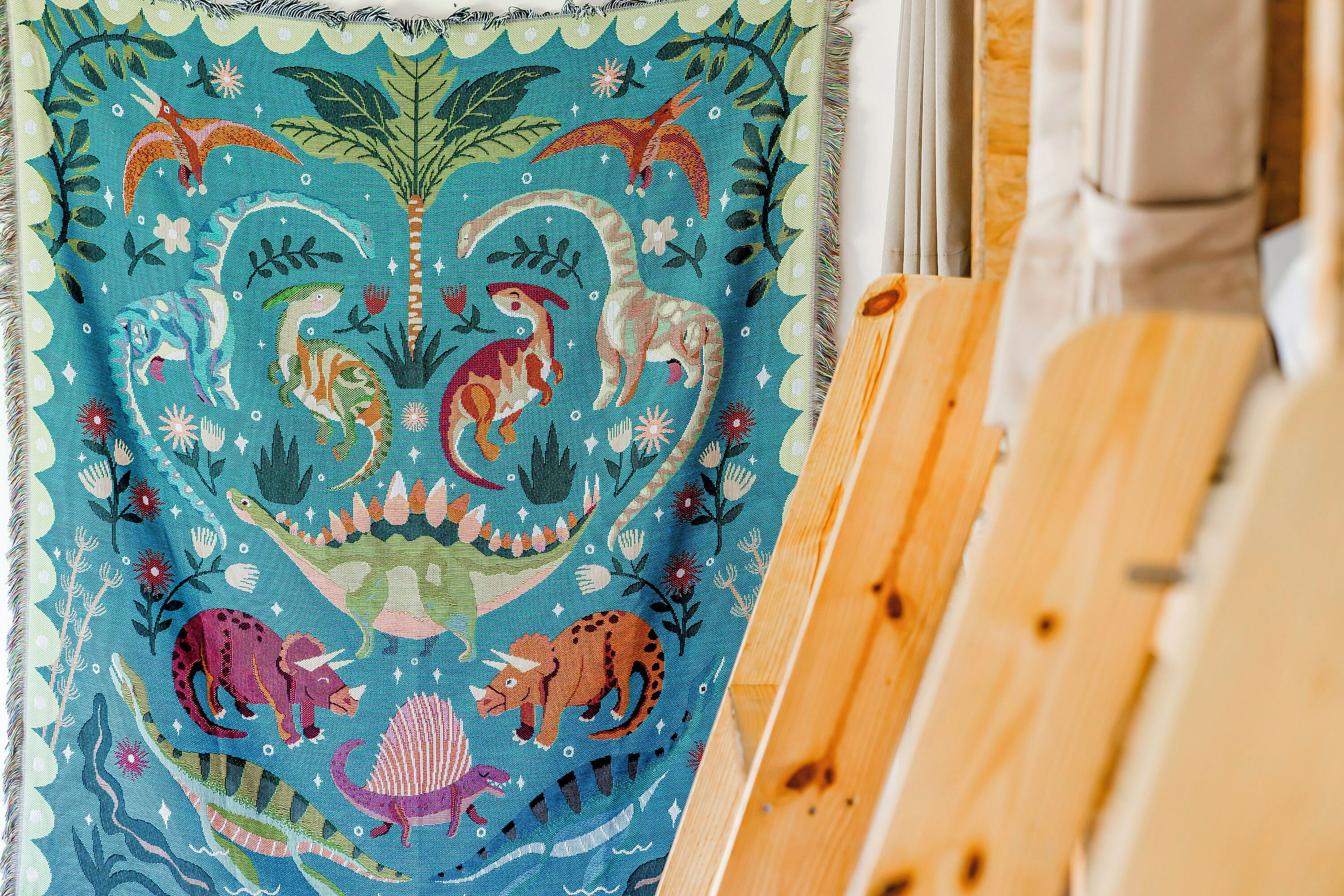 A colorful tapestry with prehistoric creatures and plants.