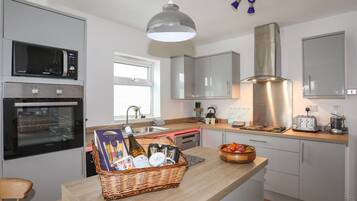 Een vaatwasser, een waterkoker, kookgerei, borden en bestek