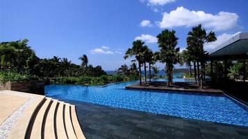 Una piscina al aire libre, sillones reclinables de piscina