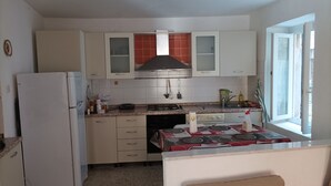 A compact kitchen with white cabinets, a built-in stove, and a window providing natural light. - Vacation home in Tuscany park of Apuane near spa. Five Lands and Versilia (Monzone)
