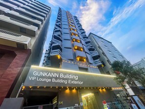The exterior of the Gunkann Building, a high-rise structure with multiple balconies and a sign indicating it is a VIP Lounge Building.