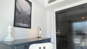A modern room with a desk, chair, and a large black door. - Black White Modern Spacious (Tunis)