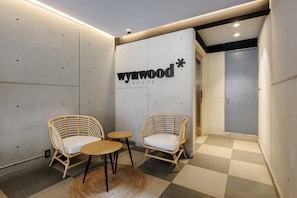Relax in the Wynwood HOUSE with two comfortable chairs and a small table.