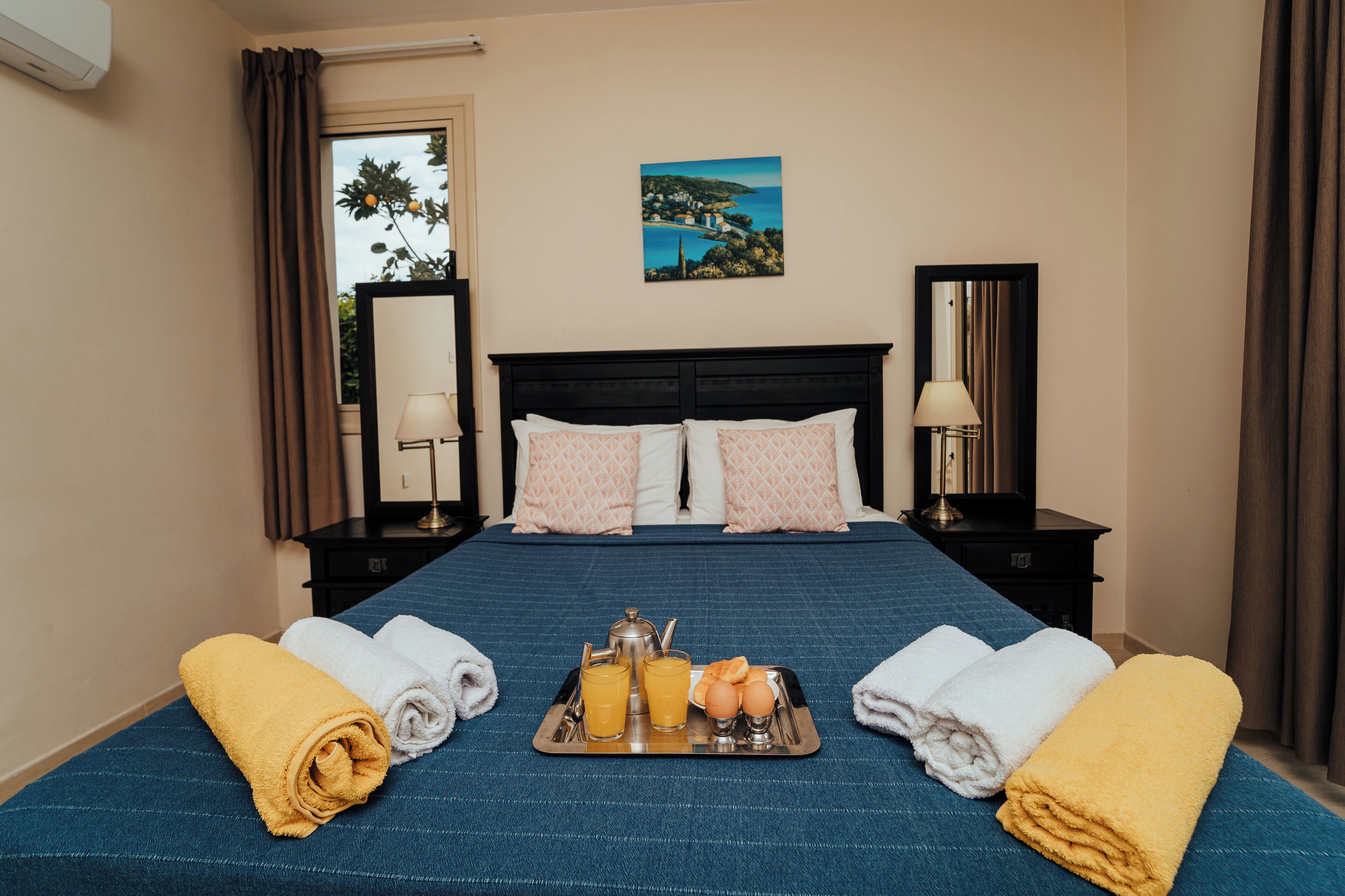 Ein Hotelzimmer mit Bett, Frühstückswagen und Handtüchern.