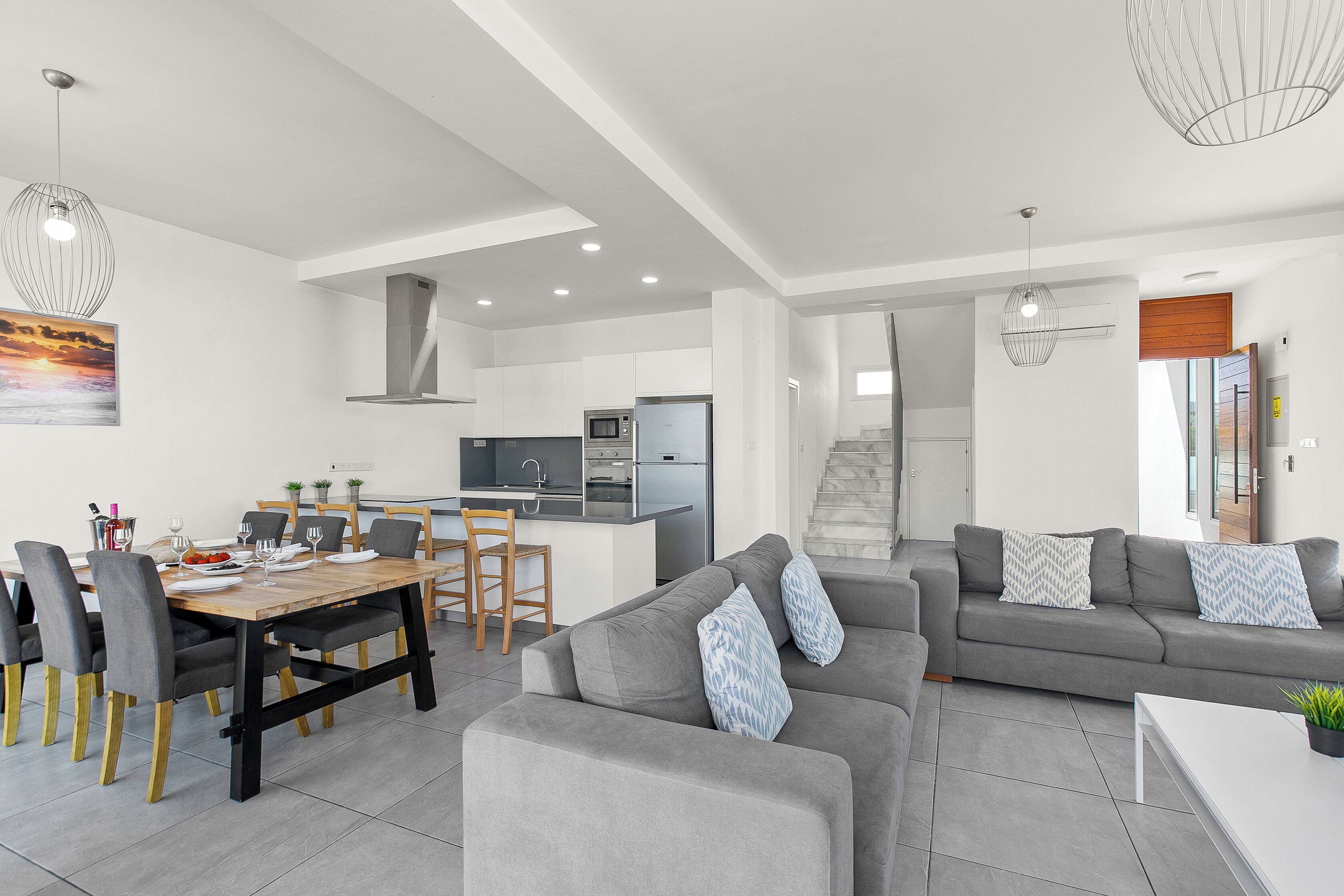 A modern living space with a dining area, kitchen, and seating area.