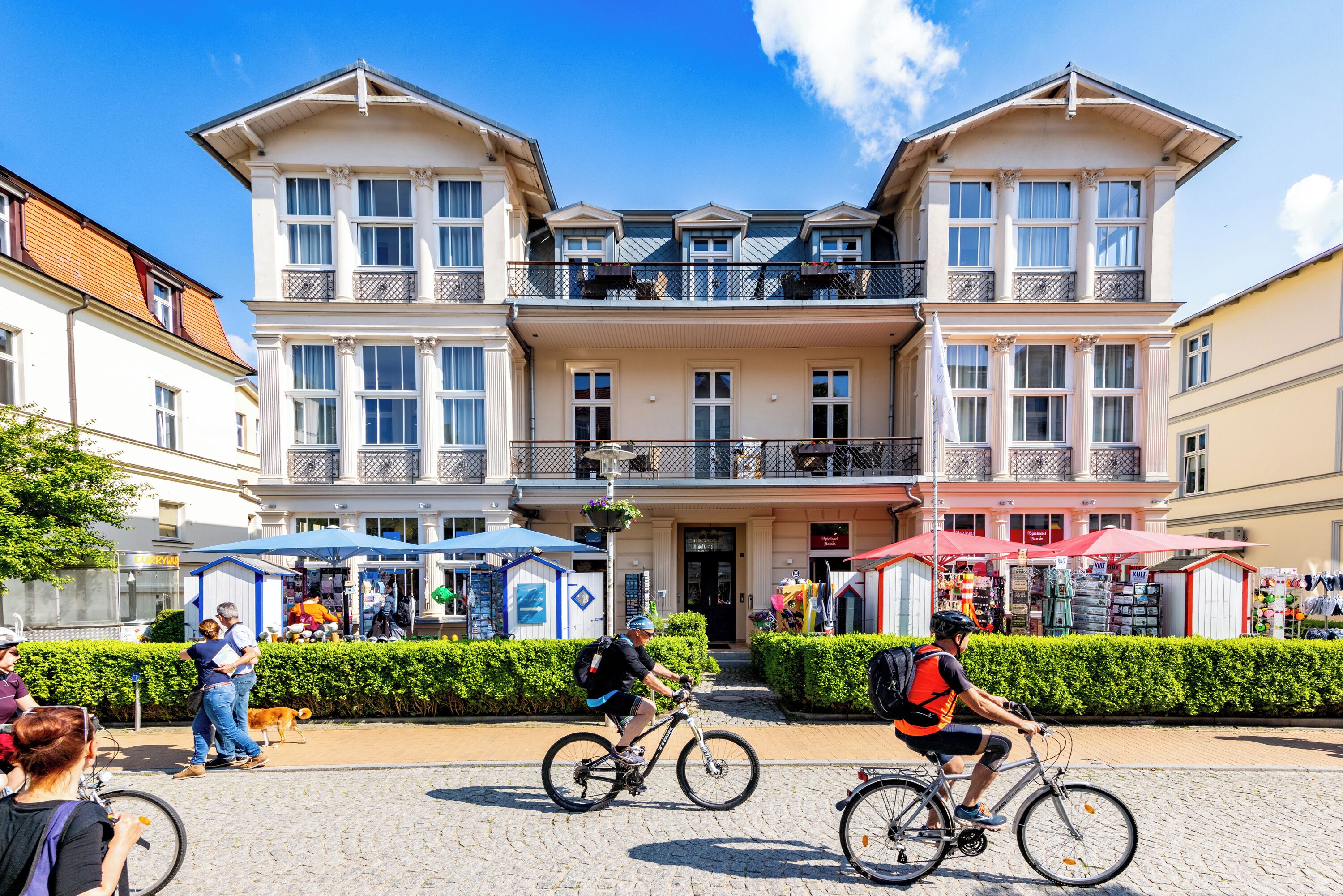 Un immeuble doté d’une entrée centrale, de balcons et d’un espace commercial situé au rez-de-chaussée.