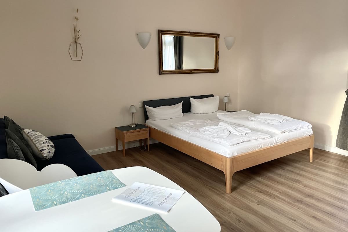 A hotel room with a bed, bedside tables, a desk, and a chair.