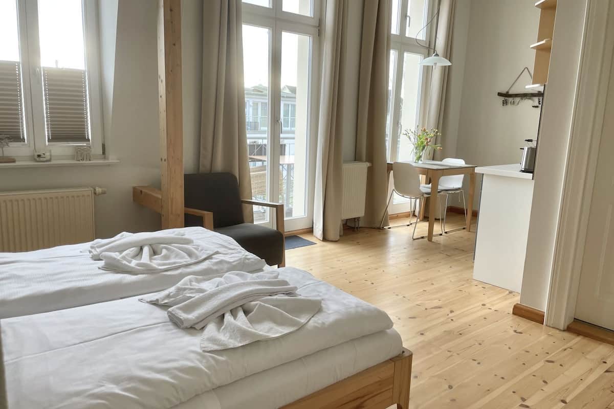 A hotel room with two beds, a desk, and a chair.