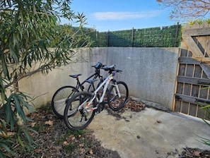 Bicycles are secured against a wall in a peaceful outdoor space.
