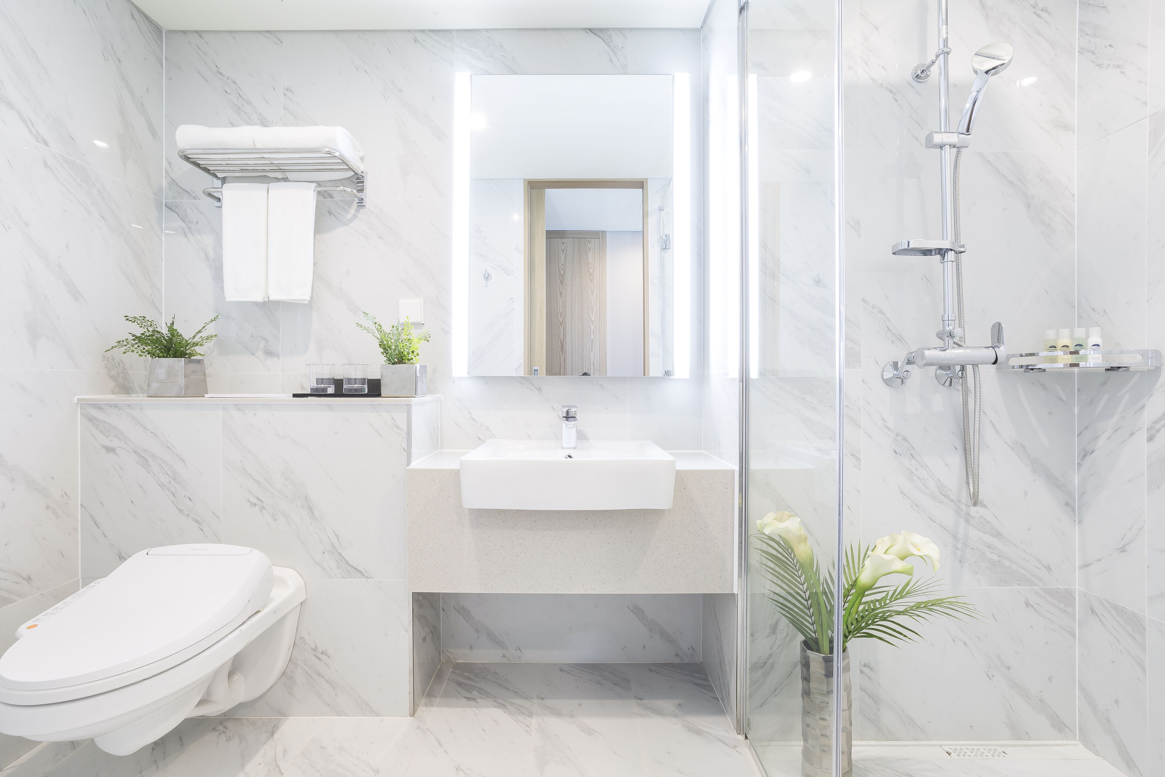 A modern bathroom with a toilet, sink, and shower.