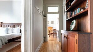 A narrow hallway with a bed on the left and a wooden cabinet on the right. - Timeless Treasure: Near the City Centre & WiFi (Launceston)