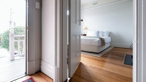 A bedroom with a bed, a nightstand, and a window. - Timeless Treasure: Near the City Centre & WiFi (Launceston)