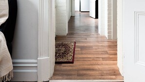 A hallway with wooden flooring, white walls, and a rug. - Timeless Treasure: Near the City Centre & WiFi (Launceston)