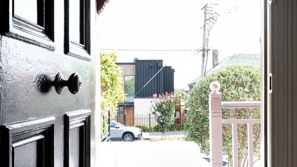A doorway leading to a porch with a white railing, a small tree, and a parked car visible in the background. - Timeless Treasure: Near the City Centre & WiFi (Launceston)