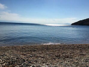 A pebbly beach with calm water and distant mountains. - Traditional Luxury House In Pelion "erato" (South Pelion)