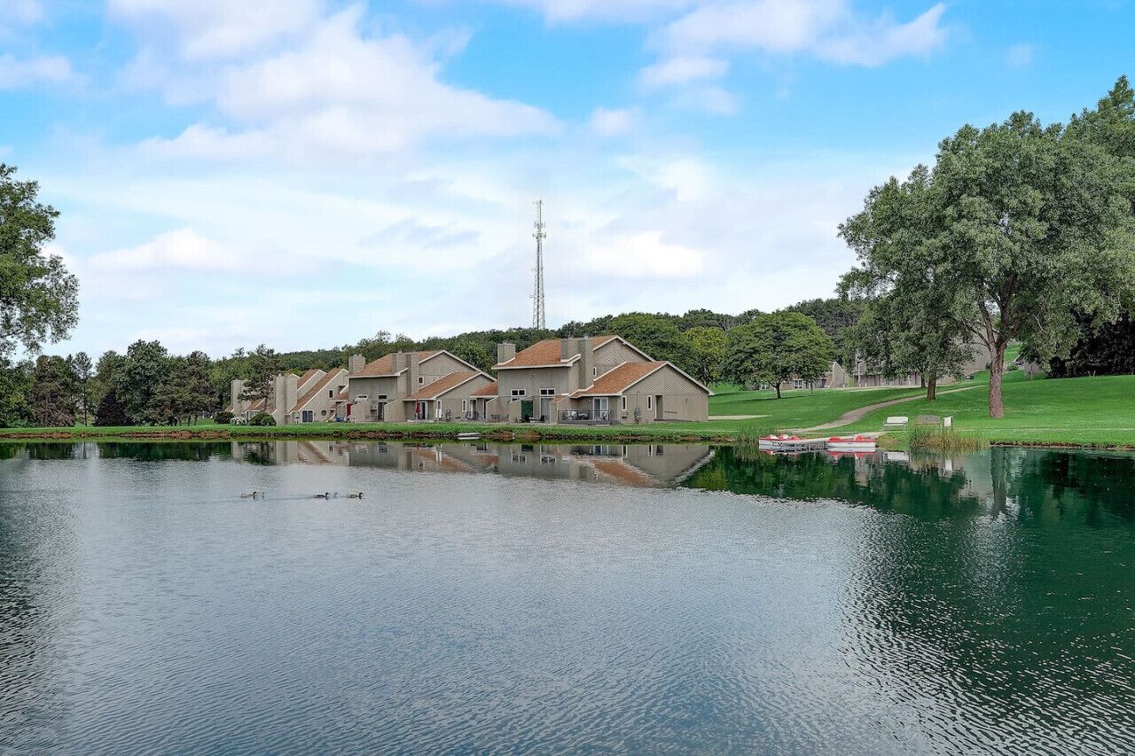 Zona residencial con casas, un estanque y un campo de golf.