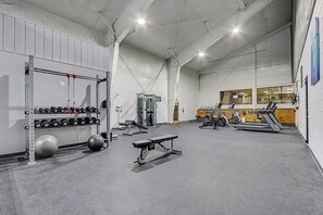 A spacious gym with weightlifting equipment, treadmills, and cardio machines.