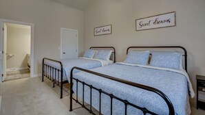 A bedroom with two beds, a door, and two signs on the wall.