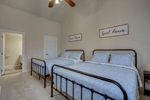 A bedroom with two beds, a door, and two signs on the wall.