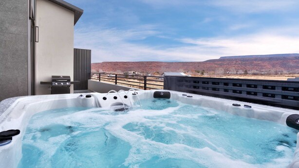 A hot tub on a balcony with a view of a mountainous landscape. - Vizcaya #2 - Moab's Newest Luxury Rental (Hot Tub) (Moab)