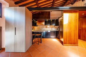 A modern kitchen with a wooden cabinet, a dining area with chairs, and a kitchen island. - ApartmentsArena - Residenza Degli Scaligeri (Verona)