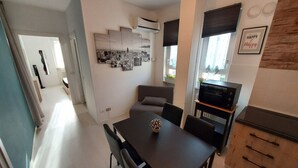 Une cuisine moderne avec un coin repas, comprenant une table à manger noire, des chaises et un vase décoratif.