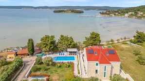 Ein großes Haus mit Swimmingpool und Seeblick.