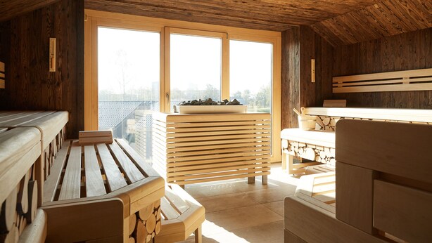 Un interior de madera con un banco, una mesa y un ventanal con vistas al exterior.