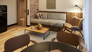 Una sala de estar moderna con un sofá, dos sillones, una mesa de centro con fruta, un refrigerador y una pared de acento de madera.