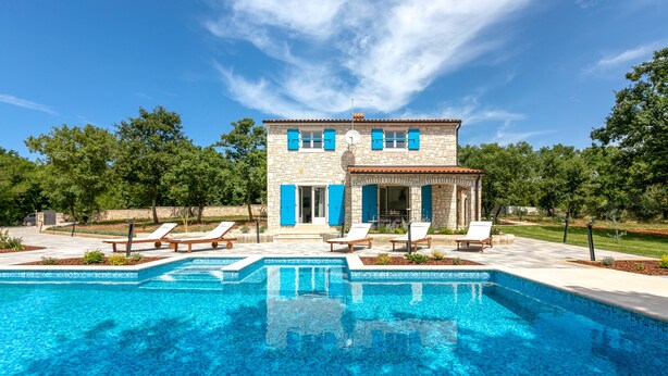 A stone building with blue shutters, a swimming pool, and lounge chairs. - Villa Irena Funtana in a quiet location, with pool close to Zelena Laguna Resort (Funtana)
