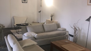 Una sala de estar moderna con un sofá, una mesa de centro y una lámpara.