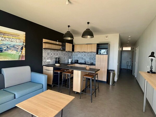 A modern kitchen with a central island, bar stools, and pendant lighting. - 2-bed apt, direct beach access, ground floor, pool, pets OK (La Tranche-sur-Mer)