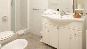Baño con inodoro, lavamanos y ducha.